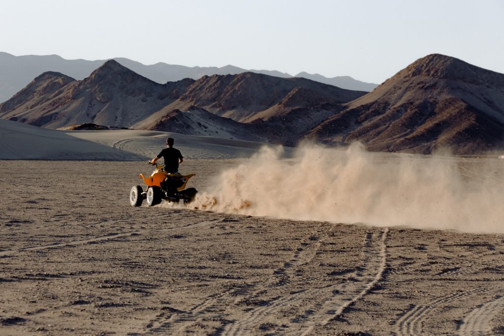 Man riding on ATV heading toward hills